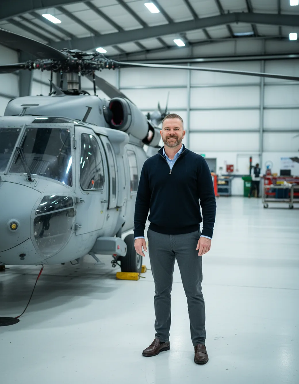 Andy Carey in an aerospace hangar beside a helicopter